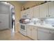 Charming kitchen featuring white cabinets, modern appliances, and neutral backsplash at 4904 Long Meadow Dr, Leesburg, FL 34748