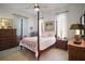 Bright main bedroom showcasing a four-poster bed, tiled floor, and a ceiling fan at 4904 Long Meadow Dr, Leesburg, FL 34748