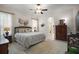 Comfortable main bedroom featuring large bed, tiled floor, ceiling fan, dresser and ensuite bathroom at 4904 Long Meadow Dr, Leesburg, FL 34748