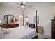 Bright main bedroom with tiled floor, ceiling fan, dresser and view into ensuite bathroom at 4904 Long Meadow Dr, Leesburg, FL 34748