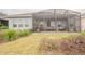 Backyard featuring a screened-in patio and landscaped garden beds at 525 Narrow View Ln, Groveland, FL 34736