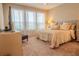 Bright bedroom with large windows, plush carpet, and a comfortable bed with decorative pillows at 525 Narrow View Ln, Groveland, FL 34736