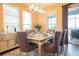 Formal dining room with modern chandelier, elegant table setting, and sliding door access to the patio at 525 Narrow View Ln, Groveland, FL 34736