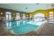 Bright indoor pool area with high ceilings, tile flooring and volleyball net at 525 Narrow View Ln, Groveland, FL 34736