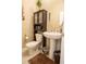 Well-maintained powder room with a pedestal sink, decorative cabinet, and attractive accents at 525 Narrow View Ln, Groveland, FL 34736