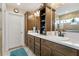 Beautiful bathroom features double sinks, wood cabinets, white counters and tiled shower at 5311 Eads Ter, The Villages, FL 32163