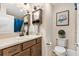 Clean bathroom with light-colored cabinets, vanity, shower with blue curtain, toilet, and modern decor at 5311 Eads Ter, The Villages, FL 32163