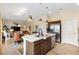 Kitchen island overlooking the living and dining areas and featuring stainless steel appliances and bar seating at 5311 Eads Ter, The Villages, FL 32163