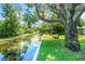 A serene waterfront view from the backyard with lush greenery and benches for seating at 5319 Eagles Nest Rd, Fruitland Park, FL 34731
