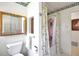 Bathroom features a tub with floral shower curtain and wooden framed mirror at 5319 Eagles Nest Rd, Fruitland Park, FL 34731