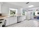 Open kitchen with stainless steel dishwasher, tile floor, and refrigerator at 5319 Eagles Nest Rd, Fruitland Park, FL 34731