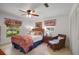 Inviting bedroom with a ceiling fan, tile floors, and bright natural light from the windows at 5319 Eagles Nest Rd, Fruitland Park, FL 34731