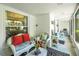 Cozy sunroom with white wicker furniture, bright red pillows, and views of the outdoors at 5319 Eagles Nest Rd, Fruitland Park, FL 34731