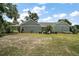 View of the back of the house with a large backyard and mature trees at 622 W 11Th Ave, Mount Dora, FL 32757