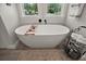 Bright and airy bathroom with a soaking tub situated by two windows with views of a well landscaped exterior at 622 W 11Th Ave, Mount Dora, FL 32757