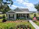 Charming single story home with manicured lawn, covered porch, American flag and water view in the distance at 622 W 11Th Ave, Mount Dora, FL 32757