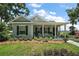 Charming single-story home with a covered porch and manicured lawn featuring meticulous landscaping at 622 W 11Th Ave, Mount Dora, FL 32757