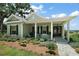 Inviting single-story home with a covered porch, lush garden beds, and a view of the water at 622 W 11Th Ave, Mount Dora, FL 32757