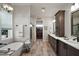 Bright main bathroom features dual sinks, stand alone tub, walk-in shower, and access to a walk-in closet at 622 W 11Th Ave, Mount Dora, FL 32757