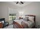 Serene main bedroom features a tray ceiling, a dark wood bed frame, and stylish grey wood-look flooring at 622 W 11Th Ave, Mount Dora, FL 32757