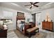 Elegant main bedroom boasts a decorative ceiling fan, paneled walls, and an antique decorative bed with a dark wood finish at 622 W 11Th Ave, Mount Dora, FL 32757