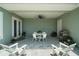 Inviting covered patio featuring white Adirondack chairs, a grill, and a dining table set for six at 622 W 11Th Ave, Mount Dora, FL 32757