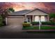 Charming single-story home featuring stone accents, landscaped front yard, and two-car garage at sunset at 6906 Glenbrook Dr, Lakeland, FL 33811