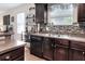 Modern kitchen featuring dark wood cabinets, stainless steel appliances, and stylish tile backsplash at 6906 Glenbrook Dr, Lakeland, FL 33811