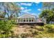 Landscaped backyard showcasing a modern home addition with expansive windows and an outdoor deck at 7921 Sebago Ct, Orlando, FL 32835