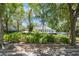Exterior daytime view of home with deck, manicured landscaping, and surrounded by mature trees at 7921 Sebago Ct, Orlando, FL 32835