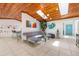 Spacious living room with a grey sofa, glass coffee table, skylights, and blue entry door at 7921 Sebago Ct, Orlando, FL 32835