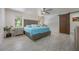 Bright main bedroom featuring a statement headboard, a ceiling fan, and a wood accent door at 7921 Sebago Ct, Orlando, FL 32835