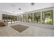 Sunroom filled with natural light through expansive windows, showcasing tile flooring and a comfortable chair at 7921 Sebago Ct, Orlando, FL 32835