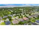 Aerial view of a residential neighborhood with lush trees and a lake in the distance at 9413 Ivywood St, Clermont, FL 34711
