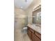 Bright bathroom features a walk-in shower with glass door and single vanity with a large mirror at 9413 Ivywood St, Clermont, FL 34711