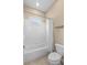 Bright bathroom with a white tiled shower over tub and a beige tiled floor at 9413 Ivywood St, Clermont, FL 34711