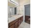 Bathroom featuring a double sink vanity with granite countertop and dark wood cabinetry at 9413 Ivywood St, Clermont, FL 34711