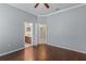 Bedroom featuring hardwood floors, ceiling fan, and a view into the ensuite bathroom at 9413 Ivywood St, Clermont, FL 34711
