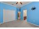 Bedroom with blue walls, carpet, closet, ceiling fan, TV mount, and bathroom access at 9413 Ivywood St, Clermont, FL 34711