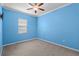 Bedroom featuring blue walls, neutral carpet, white trim and a ceiling fan at 9413 Ivywood St, Clermont, FL 34711