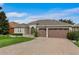 Charming single-story home with a paved driveway and a two-car garage at 9413 Ivywood St, Clermont, FL 34711