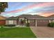 Charming single-story home featuring a well-manicured lawn, three-car garage, and elegant stone accents at 9413 Ivywood St, Clermont, FL 34711