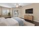 Bright main bedroom with dark wood floors, a ceiling fan, and sliding door access to the patio at 9413 Ivywood St, Clermont, FL 34711