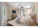 Serene main bedroom with dark wood floors, ceiling fan, slider, and a view of the ensuite bathroom at 9413 Ivywood St, Clermont, FL 34711