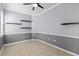 A functional office space featuring gray walls, floating shelves, and a ceiling fan at 9413 Ivywood St, Clermont, FL 34711