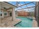 Screened in pool and spa with brick paver patio, covered lanai, and fountain at 9413 Ivywood St, Clermont, FL 34711