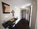Inviting hallway with dark wood floors, neutral walls, and a console table with decorations at 999 W Juniata St, Clermont, FL 34711