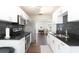 Modern kitchen with white cabinets, black countertops, stainless steel appliances and wood floors at 999 W Juniata St, Clermont, FL 34711