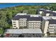 An aerial view shows the condo buildings, with water views, covered parking, and mature landscaping at 101 N Grandview St # 103, Mount Dora, FL 32757