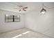 An empty bedroom contains neutral carpet, a window, and a ceiling fan with lights at 101 N Grandview St # 103, Mount Dora, FL 32757